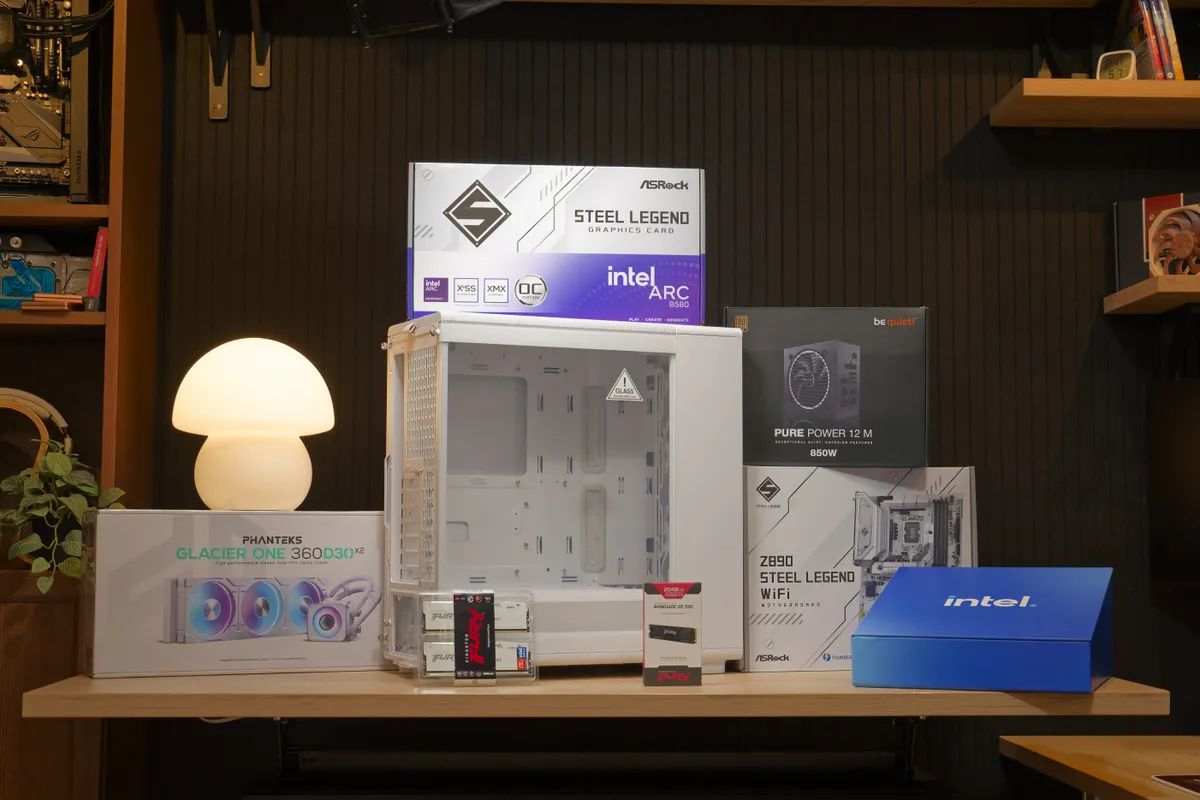 مجموعه‌ای از قطعات سخت‌افزاری آنباکس شده شامل مادربرد، کارت گرافیک Intel Arc و منبع تغذیه روی میز کار.