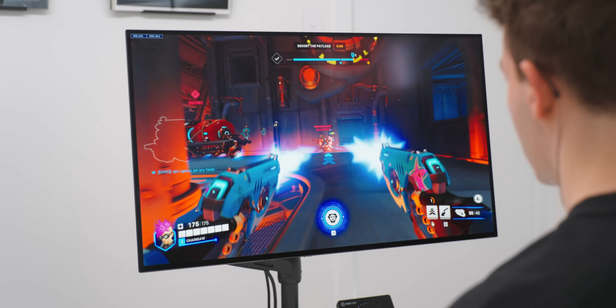 شخصی در حال بازی ویدئویی شوتر اول‌شخص روی یک مانیتور OLED تخت.