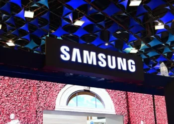 غرفه نمایشگاهی Samsung با لوگوی بزرگ و نورپردازی‌شده در Indian Mobile Congress 2025، همراه با سقف هندسی آبی‌رنگ و نمایشگرهای بزرگ، که حضور رسمی سامسونگ در این رویداد فناوری را نشان می‌دهد.