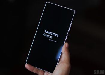 گوشی سامسونگ در دست که در حال بوت شدن است و لوگوی "Samsung Galaxy Secured by Knox" را نشان می‌دهد.