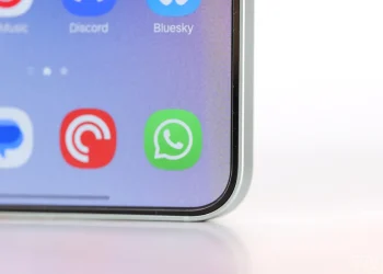 نمای نزدیک از صفحه‌نمایش یک گوشی هوشمند با آیکون سبز WhatsApp در میان سایر اپلیکیشن‌ها، با تمرکز بر رابط کاربری و پیام‌رسان‌های موبایلی