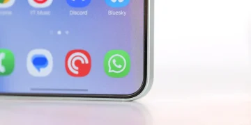 نمای نزدیک از صفحه‌نمایش یک گوشی هوشمند با آیکون سبز WhatsApp در میان سایر اپلیکیشن‌ها، با تمرکز بر رابط کاربری و پیام‌رسان‌های موبایلی