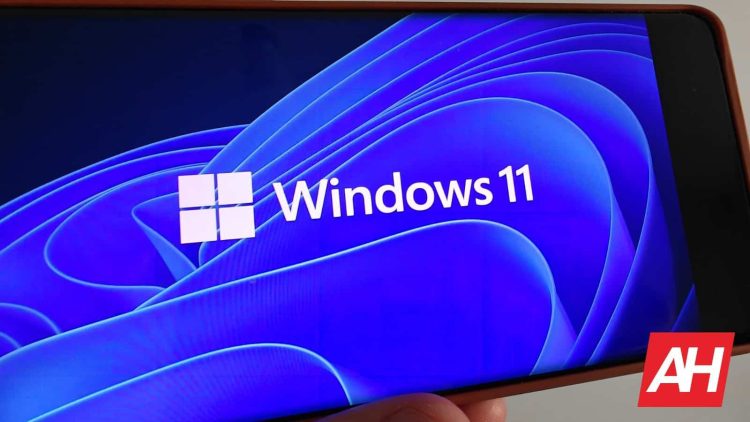 نمایش لوگوی Windows 11 و پسزمینه آبی انتزاعی روی صفحهنمایش یک گوشی هوشمند.