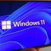 نمایش لوگوی Windows 11 و پسزمینه آبی انتزاعی روی صفحهنمایش یک گوشی هوشمند.