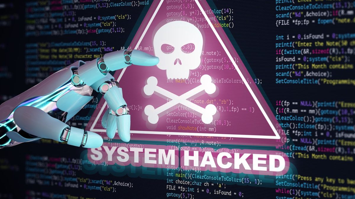 تصویر هشدار امنیت سایبری با متن SYSTEM HACKED و نماد جمجمه در یک نشان مثلثی، روی پس‌زمینه‌ای از کدهای برنامه‌نویسی؛ نمایی مفهومی از حمله باج‌افزار (Ransomware) و نفوذ به سیستم‌های رایانه‌ای.