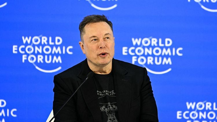 نمای یک سخنرانی رسمی در رویداد World Economic Forum با پس‌زمینه آبی و لوگوی تکرارشونده این رویداد جهانی. یک سخنران با پوشش رسمی در پشت تریبون و میکروفن قرار دارد و فضای تصویر، حال‌وهوای کنفرانس اقتصادی بین‌المللی، سیاست‌گذاری و فناوری را منتقل می‌کند.