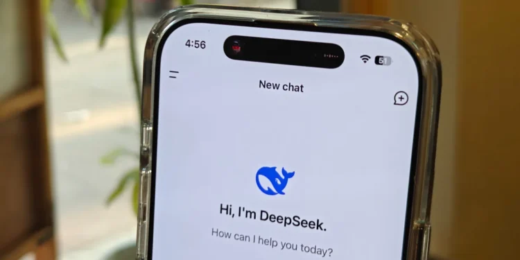 نمای نزدیک از یک گوشی هوشمند که اپلیکیشن DeepSeek AI روی صفحه آن باز است؛ متن «Hi, I’m DeepSeek. How can I help you today?» دیده می‌شود و گوشی در محیطی داخلی با نور طبیعی و گیاهان در پس‌زمینه قرار دارد.