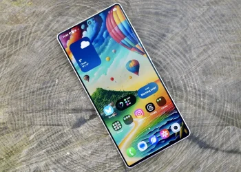 نمایی از گوشی Samsung Galaxy S25 Ultra با نمایشگر روشن و والپیپری رنگارنگ شامل بالن‌های هوای گرم و منظره طبیعی. رابط کاربری One UI با آیکن‌های اپلیکیشن، ویجت آب‌وهوا و کارت Morning Brief روی صفحه دیده می‌شود. طراحی باریک حاشیه‌ها و تمرکز تصویر بر کیفیت نمایشگر و تجربه بصری است.
