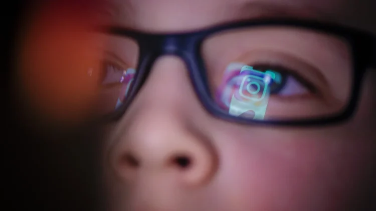 تصویر مفهومی با تمرکز بر بازتاب رابط کاربری اینستاگرام و رنگ‌های نئونی که تعامل کاربر نوجوان با شبکه اجتماعی را به صورت نمادین نشان می‌دهد