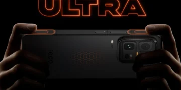 نمای پشت گوشی iQOO 15 Ultra با طراحی مشکی مات، ماژول دوربین بزرگ چندگانه و الگوی شش‌ضلعی روی بدنه، در پس‌زمینه‌ای نارنجی با حال‌و‌هوای آینده‌نگرانه و نوشته ULTRA 2077.