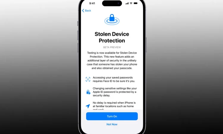 نمای معرفی قابلیت Stolen Device Protection در iOS به‌صورت صفحه تمام‌قد آیفون، با عنوان Stolen Device Protection (Beta Preview). این صفحه توضیح می‌دهد که در صورت سرقت دستگاه، دسترسی به رمزهای ذخیره‌شده و تغییر تنظیمات حساس با Face ID و تأخیر امنیتی محافظت می‌شود. در پایین صفحه دکمه‌های Turn On و Not Now برای فعال‌سازی قابلیت دیده می‌شوند.