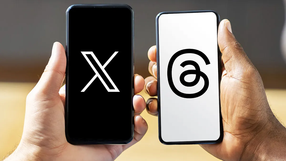 تصویر مقایسه‌ای از دو گوشی هوشمند در کنار هم که روی نمایشگر یکی لوگوی X با پس‌زمینه مشکی و روی دیگری لوگوی Threads با پس‌زمینه سفید نمایش داده شده است. این تصویر به‌صورت مفهومی رقابت مستقیم بین دو پلتفرم شبکه اجتماعی را نشان می‌دهد.