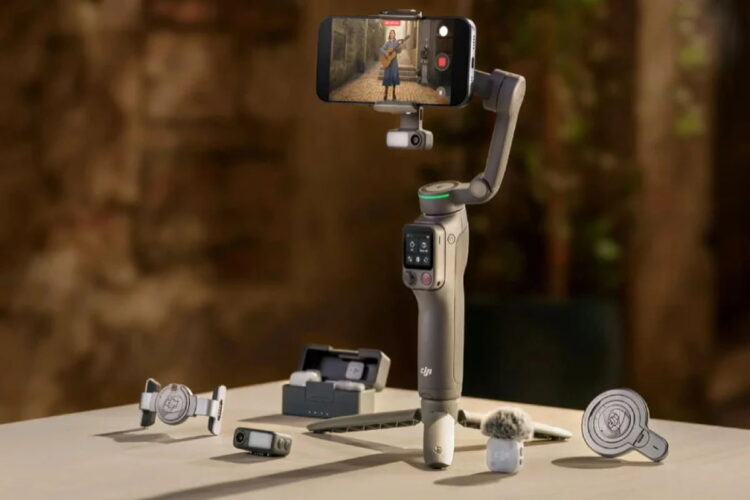 گیمبال موبایل DJI Osmo با گوشی متصل در حال ضبط ویدیو، بههمراه لوازم جانبی مانند میکروفون، پایه نگهدارنده و ریموت کنترل روی میز