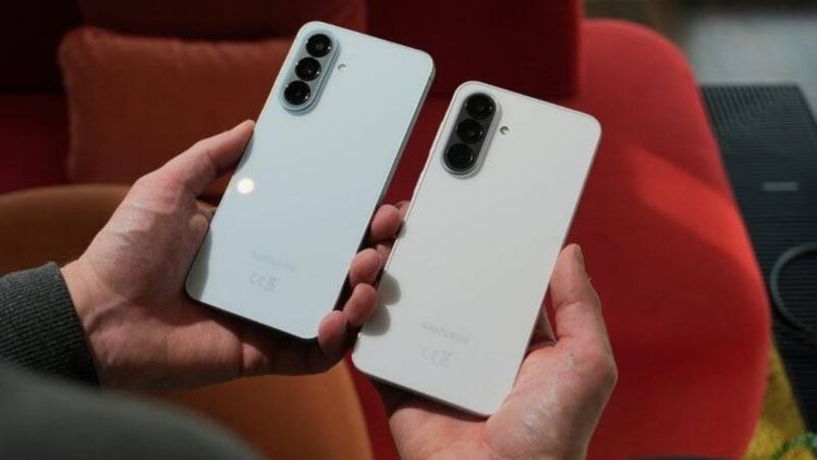 دو گوشی هوشمند سامسونگ با رنگ روشن در دست کاربر که از نمای پشت دیده می‌شوند؛ طراحی ماژول دوربین سه‌گانه عمودی و بدنه ساده و مینیمال دستگاه‌ها نشان‌دهنده طراحی نسل جدید گوشی‌های Galaxy است