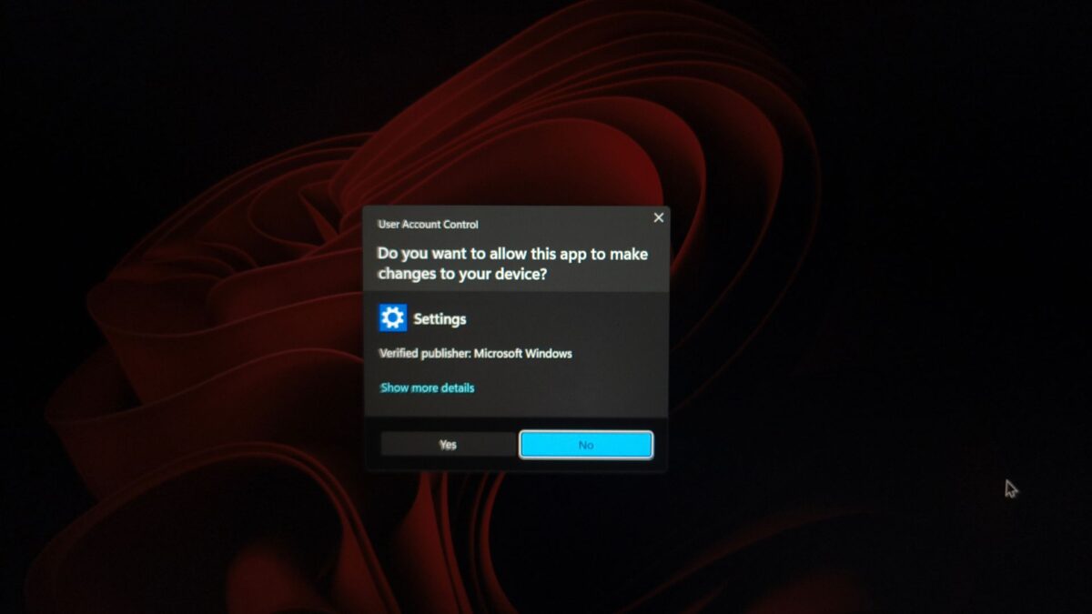 نمایی از اعلان User Account Control در ویندوز 11 با پرسش Do you want to allow this app to make changes to your device و گزینههای Yes و No روی پسزمینه تیره با خطوط قرمز گرافیکی