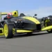 نمای جلو و در حال حرکت خودروی Ariel Atom 4RR با بدنه مشکی و زرد در پیست مسابقه.