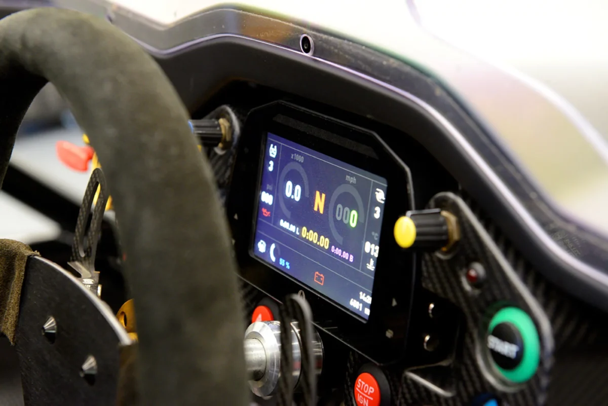 نمای نزدیک از نمایشگر دیجیتال و فرمان مسابقه‌ای داخل کابین Ariel Atom 4RR.