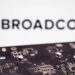 برد مدار چاپی با قطعات الکترونیکی در نمای نزدیک که در جلوی تصویر قرار دارد و لوگو و نام Broadcom به‌صورت محو در پس‌زمینه دیده می‌شود؛ تصویری مرتبط با فناوری شبکه، چیپ‌ست‌ها و صنعت نیمه‌رسانا