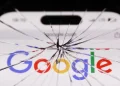 نمای نزدیک از صفحه‌نمایش گوشی هوشمند با لوگوی Google که شیشه آن از مرکز ترک خورده و شکستگی‌های شعاعی روی کل صفحه پخش شده‌اند