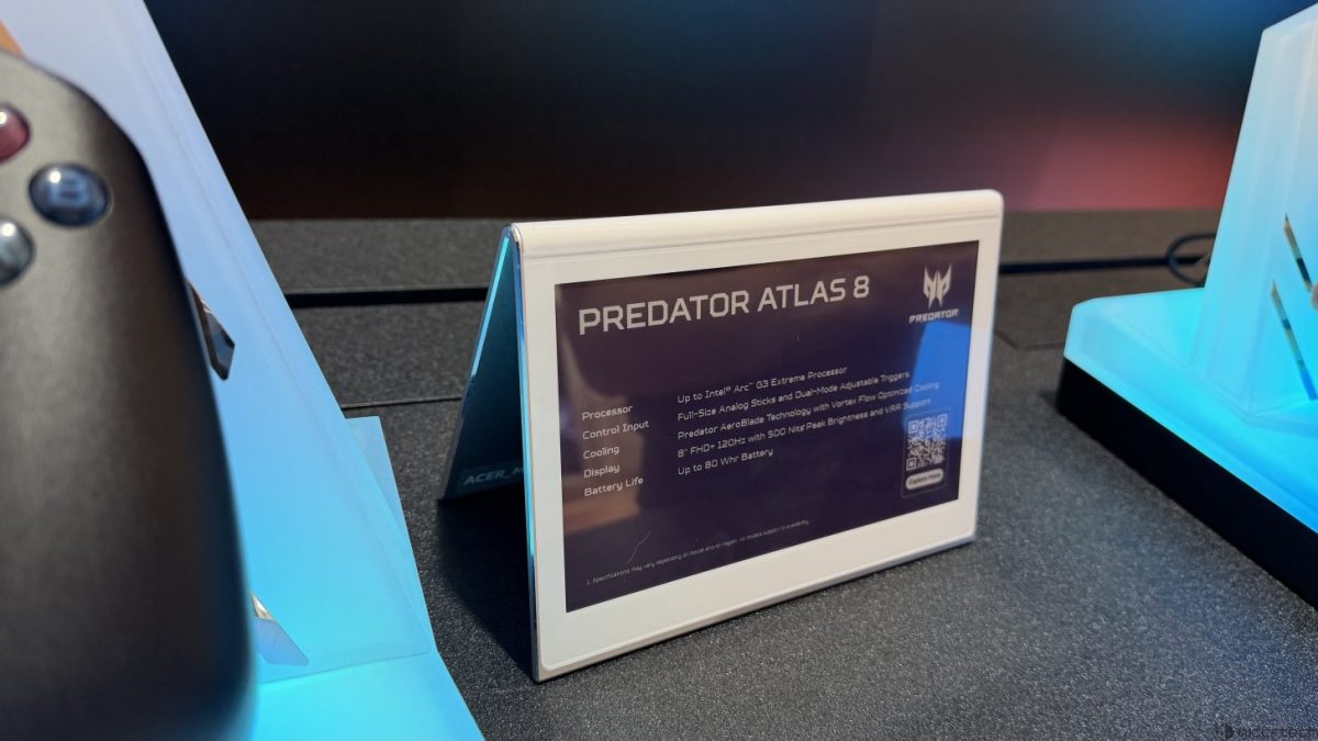نمای نزدیک از کارت معرفی محصول “Predator Atlas 8” روی میز نمایشگاهی، شامل مشخصات دستگاه و یک کد QR، در کنار استندهای آبی‌رنگ برند Predator