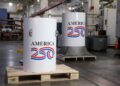 کپسول زمان پروژه America250 با بدنه فلزی سفید در مرکز صنعتی، پیش از دفن برای ۲۵۰ سال آینده آمادهسازی میشود.