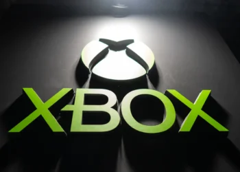 لوگوی XBOX با رنگ سبز درخشان؛ حرف X شکل بازی، به همراه نوشته XBOX که با نورپردازی از بالا روی سطح مشکی برجسته شده است