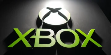 لوگوی XBOX با رنگ سبز درخشان؛ حرف X شکل بازی، به همراه نوشته XBOX که با نورپردازی از بالا روی سطح مشکی برجسته شده است