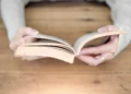 مقایسه کتاب کاغذی و لپ‌تاپ در یک تصویر مفهومی؛ نمایش تفاوت مطالعه روی کاغذ و نمایشگرهای دیجیتال