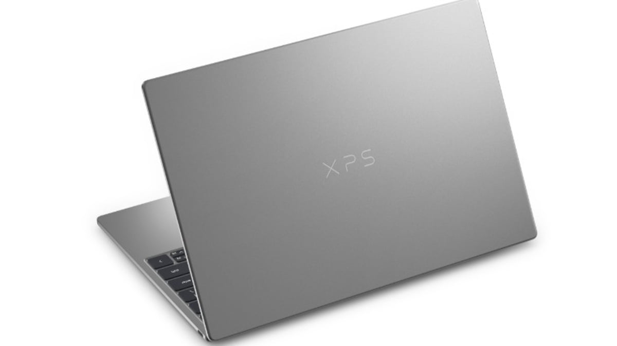 نمای سهرخ از لپتاپ Dell XPS با درِ بسته و بدنه خاکستری/نقرهای؛ لوگوی XPS در مرکز قاب پشتی روی پسزمینه سفید