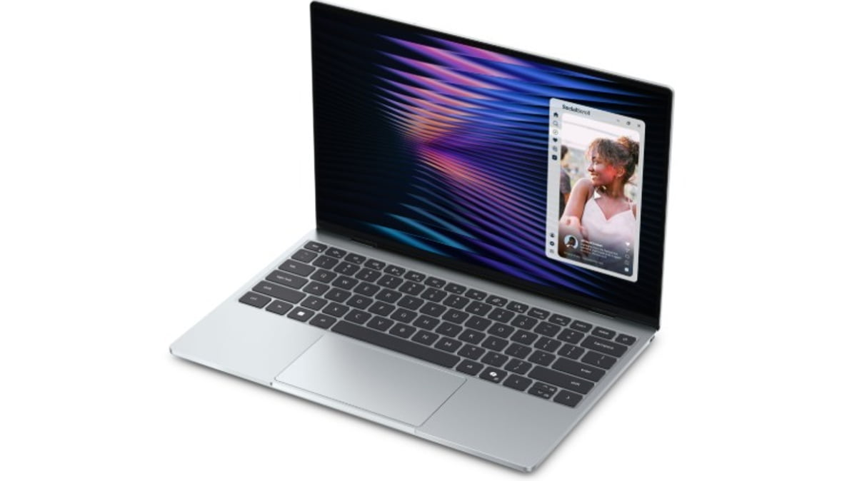 لپتاپ Dell XPS با بدنه نقرهای و کیبورد مشکی؛ نمایشگر روشن با والپیپر موجی رنگی و یک پنجره شناور رابط کاربری در سمت راست صفحه