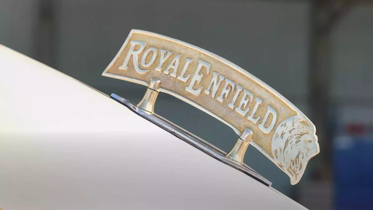 نشان فلزی Royal Enfield روی بخش جلویی بدنه موتورسیکلت سفارشی Kingsman با طراحی کلاسیک و رنگ طلایی.