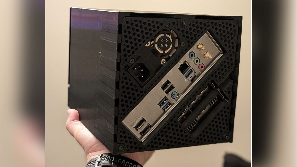 نمای پشتی یک کیس کامپیوتر مکعبی (Cube PC Case) کوچک و فشرده که مادربرد از طریق پورت‌های I/O (ورودی/خروجی) خود نمایان است؛ پورت‌های USB، صدا، شبکه (Ethernet)، HDMI و WiFi در این کیس کوچک جای گرفته‌اند که نشان‌دهنده طراحی جمع‌وجور و کاربردی آن است