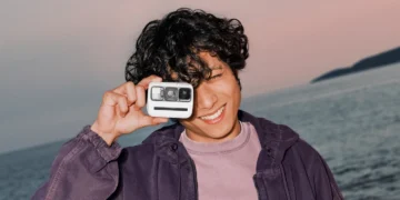 کاربری در فضای ساحلی، دوربین Polaroid Go Generation 3 را مقابل صورت خود گرفته و قابلیت حمل آسان و ابعاد کوچک آن را به نمایش میگذارد.