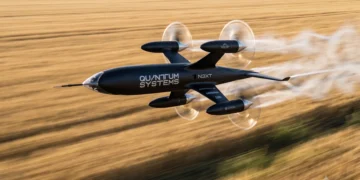 پهپاد الکتریکی Apex Recordhunter ساخت شرکت Quantum Systems در حال پرواز با سرعت بالا بر فراز یک مزرعه. این پهپاد چهارملخه برای ثبت رکورد سرعت و توسعه فناوری پهپادهای رهگیر طراحی شده است.