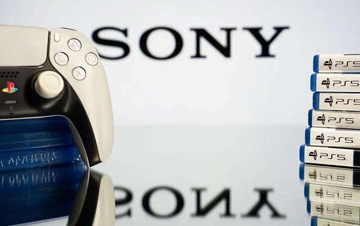 کنترلر سفید و مشکی پلی‌استیشن 5 کنار چند بسته بازی PS5 روی سطحی براق، با لوگوی SONY در پس‌زمینه»