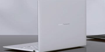 رندر استودیویی از نمای پشت لپ‌تاپ Asus Zenbook Air 2026 به رنگ سفید سرامیکی؛ لوگوی نقره‌ای ASUS Zenbook در مرکز پنل پشتی دیده می‌شود و دستگاه روی یک میز براق تیره قرار گرفته که بازتاب بدنه ظریف و مینیمال آن را نشان می‌دهد