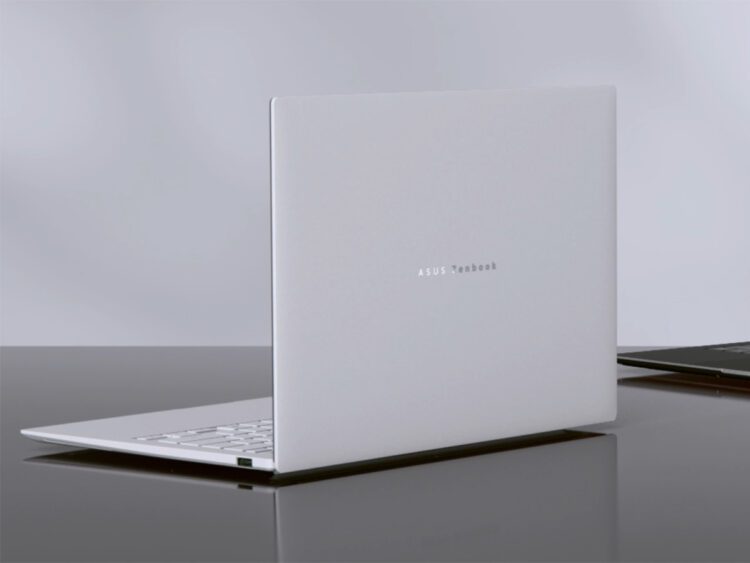 رندر استودیویی از نمای پشت لپتاپ Asus Zenbook Air 2026 به رنگ سفید سرامیکی؛ لوگوی نقرهای ASUS Zenbook در مرکز پنل پشتی دیده میشود و دستگاه روی یک میز براق تیره قرار گرفته که بازتاب بدنه ظریف و مینیمال آن را نشان میدهد