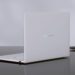 رندر استودیویی از نمای پشت لپتاپ Asus Zenbook Air 2026 به رنگ سفید سرامیکی؛ لوگوی نقرهای ASUS Zenbook در مرکز پنل پشتی دیده میشود و دستگاه روی یک میز براق تیره قرار گرفته که بازتاب بدنه ظریف و مینیمال آن را نشان میدهد