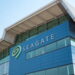 نمای بیرونی مدرن از ساختمان اداری شرکت Seagate با نمای شیشه‌ای آبی‌رنگ و سقف فلزی با طراحی هندسی. لوگوی بزرگ و نمادین سیگیت با رنگ سبز در گوشه ساختمان درج شده که به عنوان تصویر مرجع برای اخبار شرکتی و معرفی پایگاه‌های توسعه سخت‌افزار کاربرد دارد.