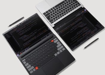 تصویر از بالا از فضای کار شامل یک لپ تاپ با کیبورد سفید و یک تبلت یا صفحه نمایش دوم در کنار آن که کدهای برنامه نویسی را نمایش می دهد و دو قلم استایلوس روی میز قرار دارند.