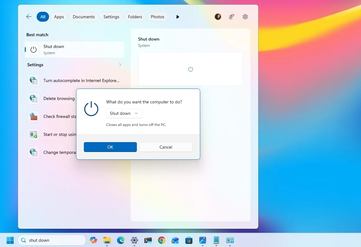 اسکرین‌شات از ویندوز ۱۱ با پس‌زمینه رنگارنگ و انتزاعی. پنجره جستجوی ویندوز (Windows Search) باز است و کاربر shut down را جستجو کرده. روی نتیجه Shut down (System) کلیک شده و یک پنجره پاپ‌آپ با عنوان “What do you want the computer to do?” نمایش داده می‌شود که در حالت پیش‌فرض “Shut down” انتخاب شده است
