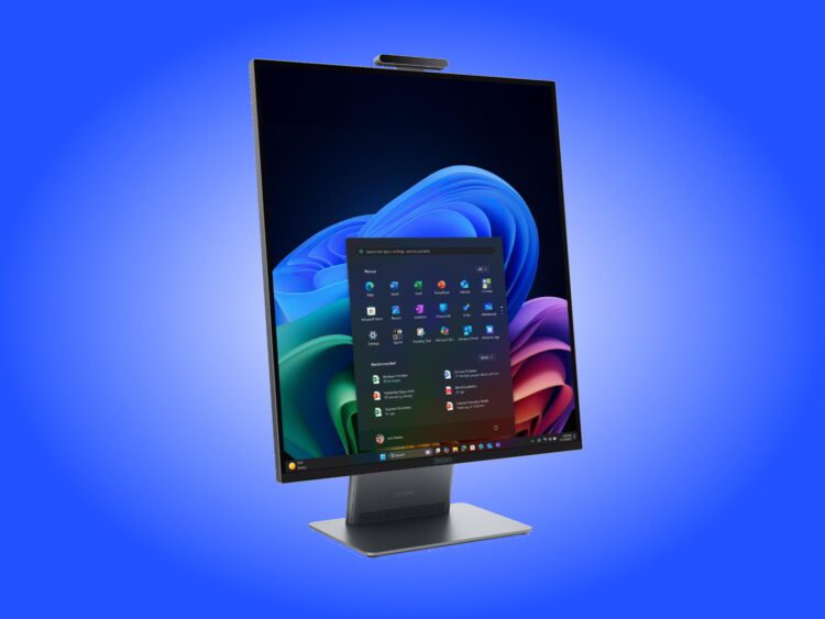رندر تبلیغاتی کامپیوتر همهکاره لنوو (ThinkCentre AIO) با نمایشگر بدون حاشیه و نسبت تصویر عمودی که در محیط ویندوز ۱۱ قرار دارد؛ منوی استارت و اپلیکیشنهای پین شده در مرکز صفحه دیده میشوند و یک وبکم عریض در لبه بالایی دستگاه تعبیه شده است. کل دستگاه روی یک پایه فلزی تخت و مدرن با لوگوی لنوو در پسزمینهای با طیف رنگی آبی قرار گرفته است