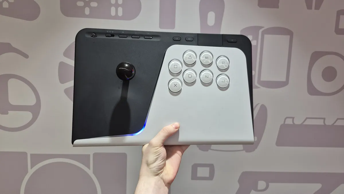 دستی که یک کنترلر آرکید سازگار با PlayStation را نگه داشته است؛ جوی‌استیک مشکی، هشت دکمه سفید، نوار نورانی آبی و پس‌زمینه بنفش با طرح‌های محو کنسول‌ها.