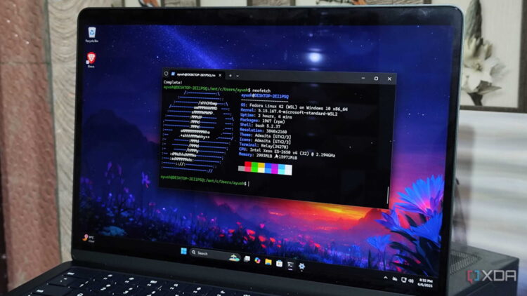 لپتاپ ویندوز 11 با پنجره ترمینال و خروجی neofetch که Fedora Linux 42 روی WSL2 را نشان میدهد، همراه با واترمارک XDA در گوشه پایین راست.