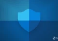 تصویر گرافیکی باکیفیت از آیکون سپر Windows Security که با سبک تخت و گرادینت‌های آبی طراحی شده و روی پس‌زمینه‌ای با طیف‌های مختلف رنگ آبی قرار گرفته است؛ لوگوی Neowin نیز در گوشه پایین سمت راست دیده می‌شود.