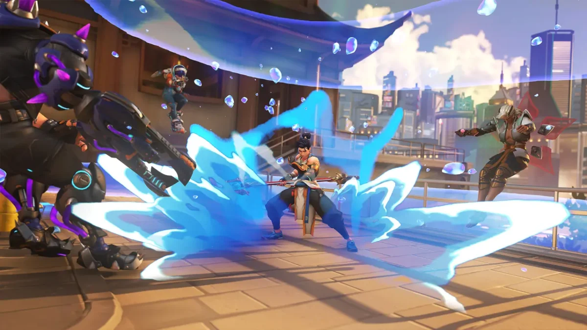 صحنهای اکشن از بازی Overwatch 2 که در آن هانزو در مرکز تصویر با حملهای آبیرنگ و موجی از انرژی روی سکوی شهری futuristic به چند دشمن اطراف یورش میبرد.