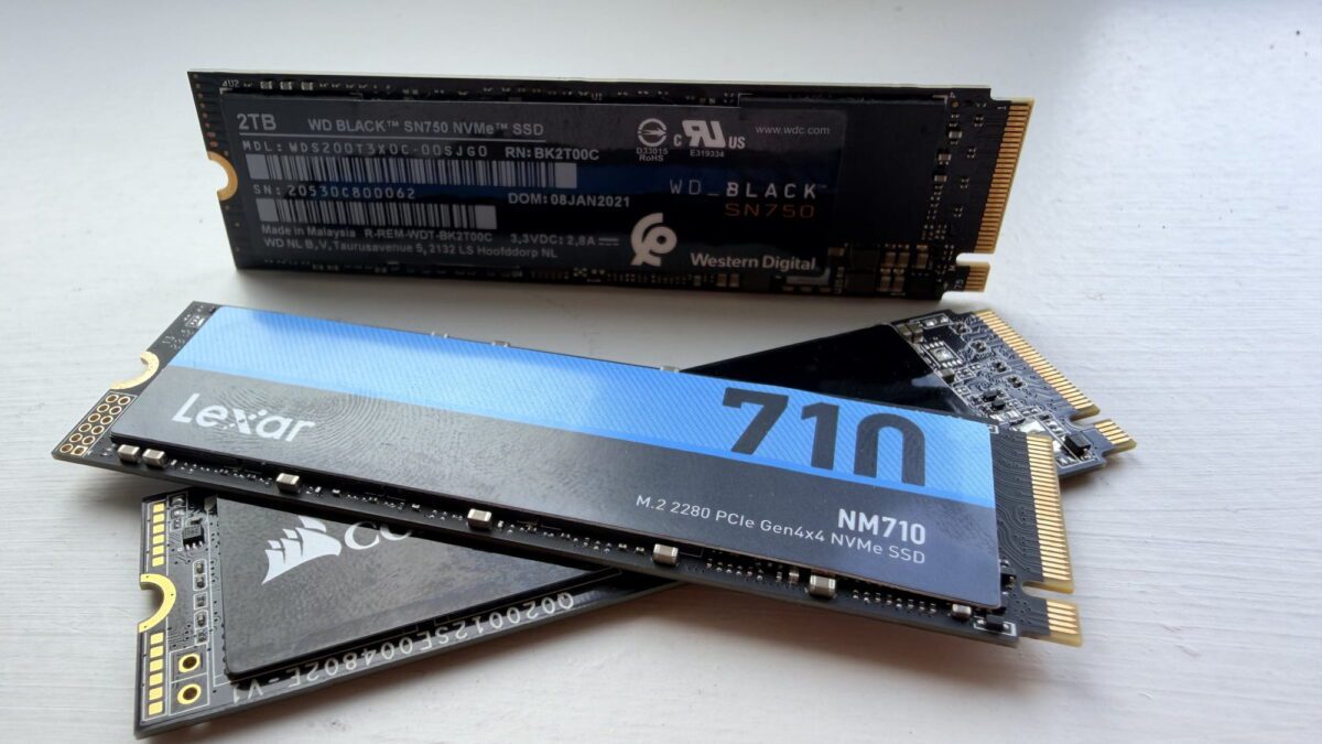 چند حافظه SSD نوع M.2 روی سطحی روشن، شامل WD Black SN750 NVMe با ظرفیت ۲ ترابایت، Lexar NM710 و یک SSD دیگر از Corsair.