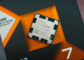 نمای نزدیک پردازنده AMD Ryzen 7 7700X3D با فناوری 3D V-Cache روی جعبه بستهبندی مشکی و نارنجی محصول.