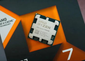 نمای نزدیک پردازنده AMD Ryzen 7 7700X3D با فناوری 3D V-Cache روی جعبه بسته‌بندی مشکی و نارنجی محصول.