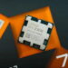نمای نزدیک پردازنده AMD Ryzen 7 7700X3D با فناوری 3D V-Cache روی جعبه بستهبندی مشکی و نارنجی محصول.